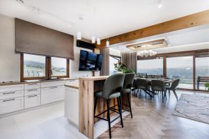 a kitchen and dining room with a table and chairs at Villa Lawendowy Prestige- balia, sauna, bilard in Czarna Góra