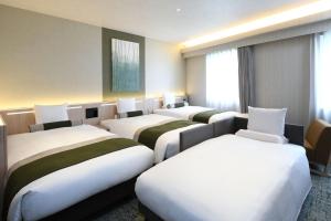 a row of beds in a hotel room at HOTEL MYSTAYS Ochanomizu Conference Center in Tokyo
