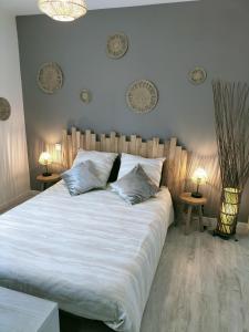 ein Schlafzimmer mit einem großen weißen Bett mit zwei Kissen in der Unterkunft Maison au calme in Bournainville