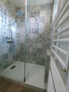 eine Dusche mit Glastüren in einem Badezimmer in der Unterkunft Maison au calme in Bournainville