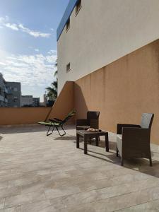 un patio con 2 sedie e un tavolo su un edificio di La Terrazza di Trapani, a due passi dal mare a Trapani