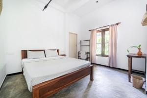 a bedroom with a bed and a window at Drifter - Rooms & Food in Midigama