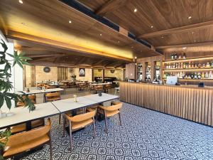 a restaurant with tables and chairs and a bar at Maximus Hotel Byblos in Jbeil