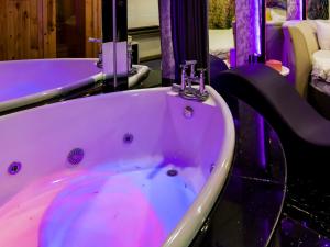 a bath tub with purple lighting in a bathroom at Cupid Hotel in Ho Chi Minh City