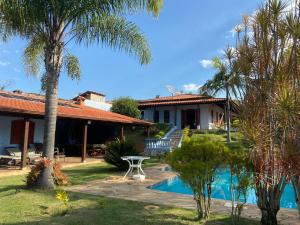 a house with a swimming pool and palm trees at Casa de Campo com Piscina in Itupeva