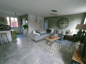 ein Wohnzimmer mit Sofa und Tisch in der Unterkunft Maison au calme in Bournainville + 5 Fotos