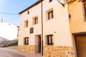 圣埃斯特万德戈尔马斯Hotel Rural La Bodega del Baldomero的街道上一座大型白色建筑,设有车库