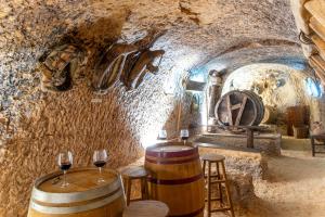 圣埃斯特万德戈尔马斯Hotel Rural La Bodega del Baldomero的酒窖,有两桶酒和酒杯