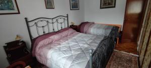 a bedroom with a metal bed with pink sheets at condominio Brembo a casa di Barbara in Foppolo
