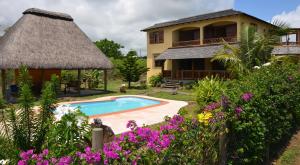 a villa with a swimming pool and a house at La Maison Soleil in Trou dʼ Eau Douce
