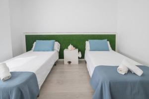 two beds in a room with blue and white at Espectacular piso con piscina, a 100 M de la playa in Cullera +34 photos