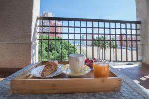 a tray of breakfast food on a table with a window at Espectacular piso con piscina, a 100 M de la playa in Cullera