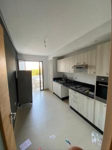 a large kitchen with white cabinets and appliances at Mansoria in Mohammedia