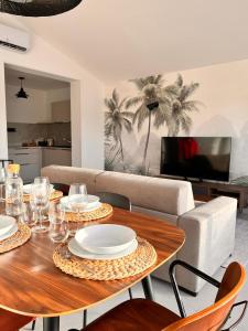 a living room with a table and a couch at L'abri Côtier in Jard-sur-Mer