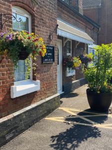 a brick building with flower boxes on the side of it at Station Cottage in Acle