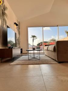 a living room with a couch and a table at L'abri Côtier in Jard-sur-Mer