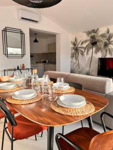 a dining room table with plates and glasses on it at L'abri Côtier in Jard-sur-Mer