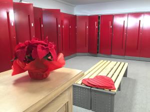 カナツェーイにあるAppartamento Sissiの赤いロッカーとベンチ付きのロッカールームが備わる客室です。