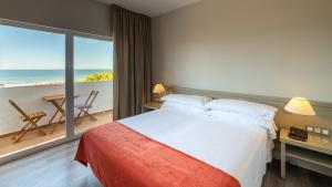 a bedroom with a bed and a view of the ocean at Pato Rojo in Punta Umbría +37 photos