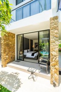 チャングーにあるThe R Apartments Pererenanのヴィラ内のベッドルーム(ベッド1台、椅子付)