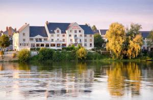 un grand bâtiment à côté d'un plan d'eau dans l'établissement Mercure Bords de Loire Saumur, à Saumur