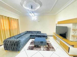 a living room with a couch and a flat screen tv at Appartement Ella Meublé in Yaoundé