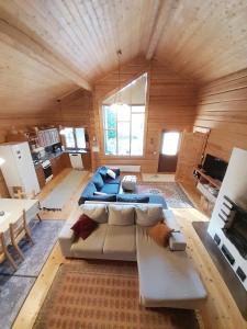 a large living room with a large couch and tables at Villa Lähde Päijätsalon järvimaisemassa in Sysmä