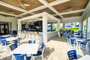 eine Terrasse mit Tischen und Stühlen sowie eine Bar in der Unterkunft 900 Pebble Beach Drive in Kissimmee