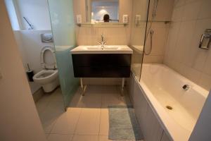 a bathroom with a sink and a tub and a toilet at Westridge - Breathtaking Views & Apartment! in Cape Town +11 photos
