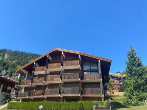 duży budynek apartamentowy z dużym balkonem w obiekcie Appartement 2 Pièces avec Terrasse et Parking, Centre Village à La Clusaz, Proche Pistes et Commerces - FR-1-437-96 w mieście Clusaz