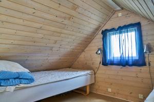 StrøbyStevns Camp的木制客房的一张床位,设有窗户