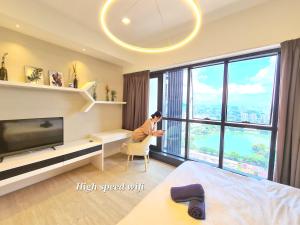 a man sitting in a chair in a room with a large window at M city service suite KLCC in Kuala Lumpur
