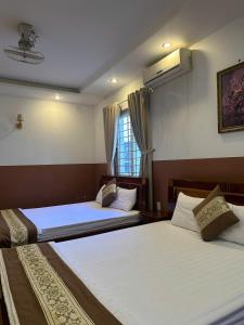 a bedroom with two beds and a window at Hưng Phát Hotel Tân Phú in Ho Chi Minh City +12 photos