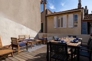 a patio with tables and chairs on a balcony at La maison des canailles in Cassis