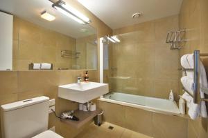 a bathroom with a sink and a toilet and a tub at Charlies Queenstown Studio Apt 103B in Queenstown