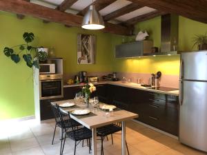 eine Küche mit einem Tisch mit Stühlen und einem Kühlschrank in der Unterkunft Le Dort'Thouars - bord de rivière et bain nordique in Thouars