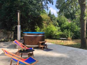 eine Sitzgruppe neben einem Fass in der Unterkunft Le Dort'Thouars - bord de rivière et bain nordique in Thouars