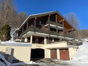 a large building with a balcony in the snow at Charmant studio rénové à La Clusaz - 4 pers, terrasse, parking - FR-1-437-102 in La Clusaz +5 photos