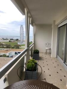 un balcone con tavolo, sedie e ruota panoramica di STUDIO 38 m2 Point Zéro a La Grande-Motte