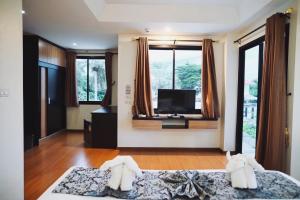 a bedroom with two beds and a flat screen tv at Narai Iyara Palace in Ban Sa Maklua