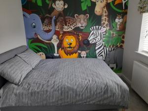 a bedroom with a mural of animals on the wall at Stylish house in Roydon in Roydon