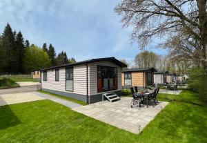 a small cabin with a picnic table in a yard at Ostseecamp Ferienhaus "Horizont" in Scharbeutz