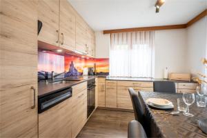 a kitchen with wooden cabinets and a dining table at Fabi`s Horu Lodge in Zermatt