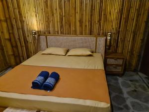 a bed with two blue pillows on it at SomWhrEls in Airsatang