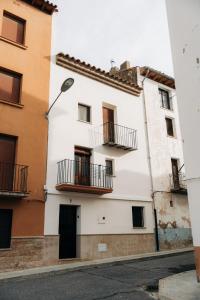 a white building with balconies on a street at Alojamiento rural Cal Sereno in Benasal