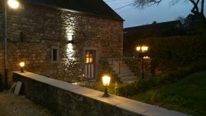 a stone house with two lights in front of it at Le Gîte Du Prieuré in Namur