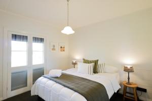 a bedroom with a large white bed and a window at Spring View Cottage in Tenterfield
