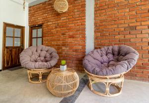 two chairs sitting next to a brick wall at Drifter - Rooms & Food in Midigama