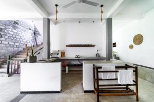 a kitchen with white walls and a table and chairs at Drifter - Rooms & Food in Midigama