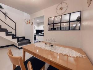 a dining room with a table with chairs and a staircase at TRP1 - Cozy 2BR Home near Aquaplanet & Clark Airport in Tacondo +23 photos